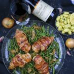 Baconlindat kycklingbröst på en bädd av hericots verts.