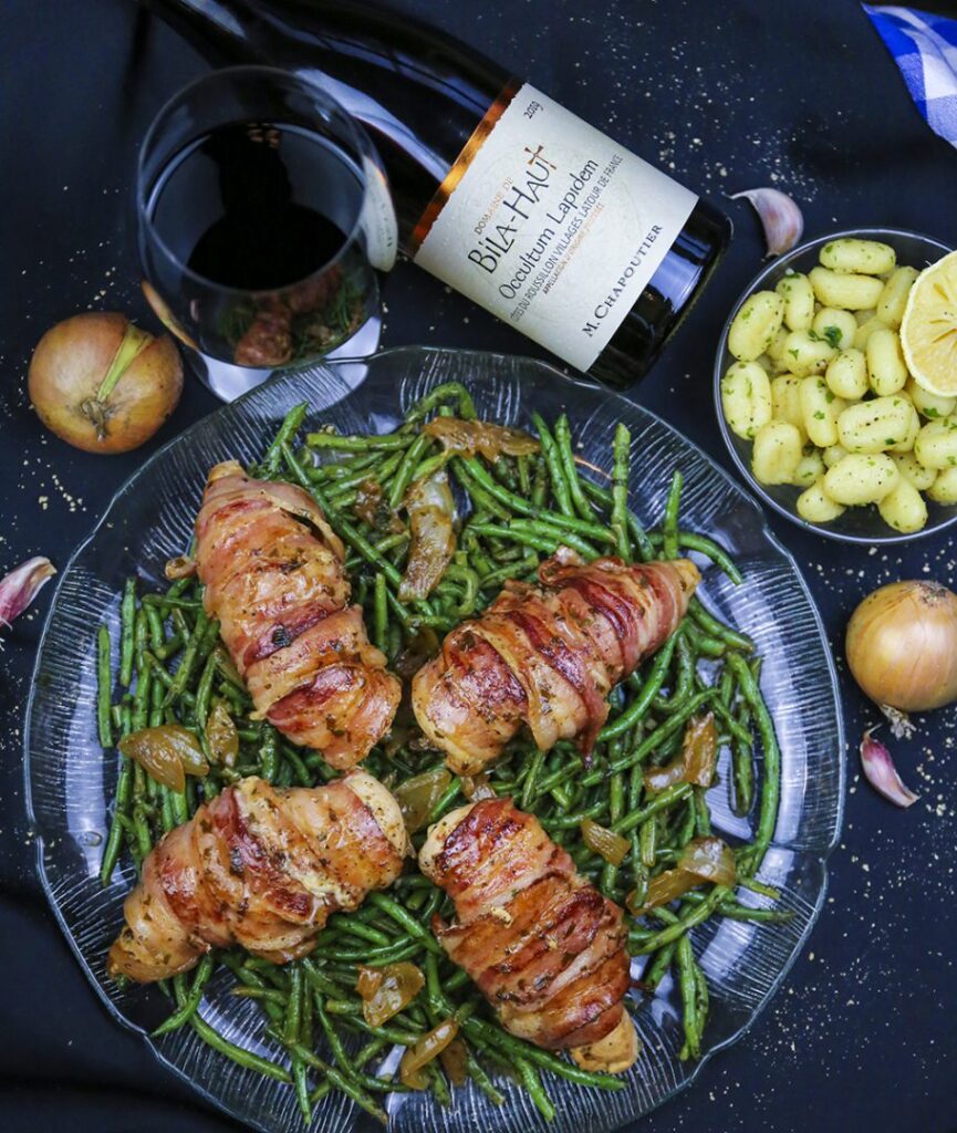 Baconlindat kycklingbröst på en bädd av hericots verts.